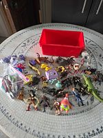 Group shot of all figures, craft punches in bags and red bin on table