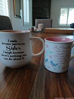 Both mugs on table showing exterior designs, heights, colors