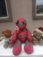 Front view of three teddy bears showing sizes, fabrics and accessories