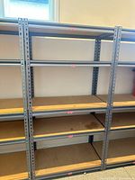 Front view of multiple assembled powder-coated steel shelving units with MDF shelves