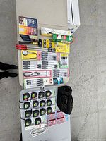 Full lot overview with tape measures, screwdriver sets, ink rollers, roaster box, tool bag, power strip, other hardware