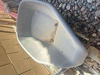 Gray plastic wheelbarrow tub interior showing wear