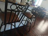 three of the metal bar stools lined along a kitchen counter