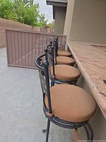 Four palm motif bar stools lined at counter