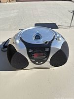 Front view of silver and black CD boombox showing LCD and speaker grilles