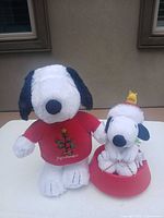Front view of both Snoopy plush figures