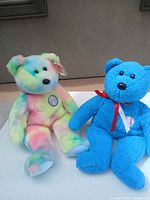 Pastel tie-dye bear and blue bear side by side showing overall appearance and patches