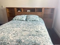 Full view of headboard with attached nightstands behind queen bed