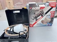 Wagner sprayer parts in open black case beside boxed RotoZip combo kit