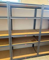Front view of assembled steel frame shelving showing four MDF shelves