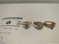 Front view of the three gold rings showing gemstones and settings