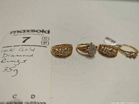 four gold diamond rings front view with lot tag