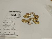 Earrings laid out with loose stones and weight card visible