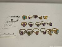 All 15 rings with note showing metal and gemstone information