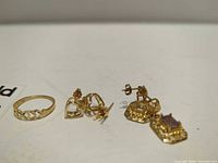 Ring and both earrings laid out on flat surface