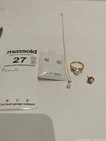 Full set showing necklace, ring, earrings pair on card, loose stud