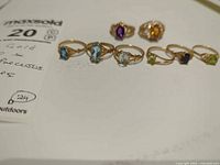 All seven rings laid out showing stone colours and settings