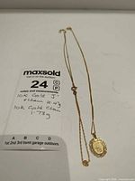 Both gold chains laid out with MaxSold lot card showing weights