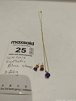 Full view of necklace and earrings beside lot card