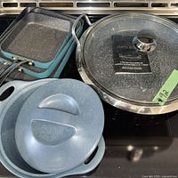 Stacked square pans, round pot, glass lid, stoneware casserole and lid