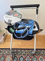 Rollator front view holding wrapped travel pillow, resistance cord and small accessories