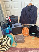 Group shot of blazer, suitcase, multiple bags, hat and fur piece