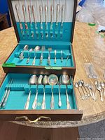 Open chest showing majority of flatware pieces and extra utensils laid out