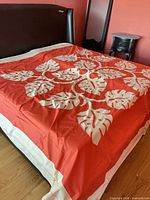 Red bedspread on king bed showing full appliqué leaf design