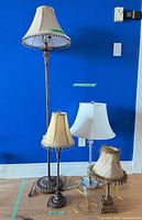 Group shot of four bronze lamps showing sizes, shades, trims