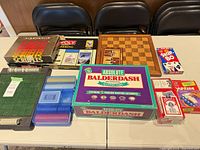 Overview of all boxed board games, chess board, card games and accessories on table