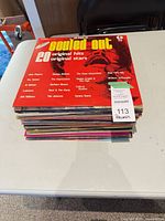 Stack of LP records topped by Souled Out compilation with auction tag indicating 113 records