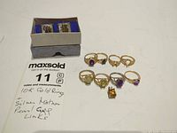 Group shot of all rings, cufflinks and note indicating metals