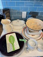 Group view of pitcher, colander, casserole, scale, leaf tray, plates, ramekins and shaker