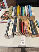 Overall view of approximately 25 mixed books laid out on table
