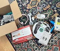 Group view showing Thermophore box, Redivive board, Conair boxed dryer, open box of hair tools and cords