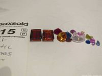 Overall group of two amber stones and mixed synthetic gemstones lined up