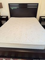 Full view of mattress on bed frame with headboard