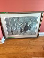Framed moose print leaning against wall