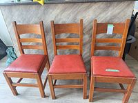 Three oak ladder back dining chairs front view