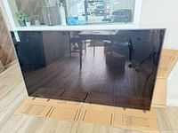 Front view of Sony 75-inch TV leaning against wall