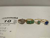 Group shot of all four yellow gold rings laid side by side