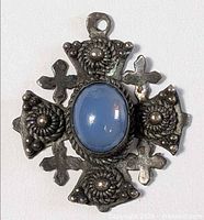 Front view of silver Jerusalem cross pendant showing blue cabochon and decorative details