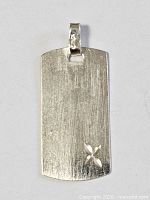 Front view showing brushed finish, X cut-out, bail