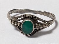 Front view showing green cabochon and open-work shoulder details