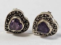 Front view of both heart stud earrings showing amethyst centers and dotted silver border