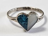 Front view of sterling silver child's ring with turquoise and mother of pearl heart inlay