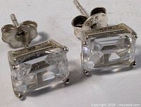 oblique view of both earrings showing stone cut, prongs, and backs