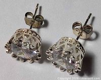 Oblique view of both earrings showing crown settings and posts
