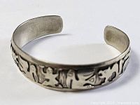 Full view of metal cuff showcasing continuous tribal motif