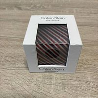 Front view of boxed Calvin Klein slim striped tie